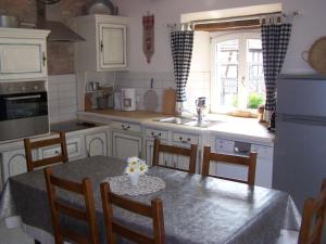 a kitchen with a table and chairs and a sink at GÎte rue de l'Ange in Hunspach