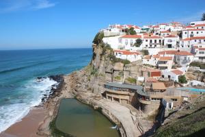 a village on a cliff next to the ocean at Azenhas Apartment in Sintra