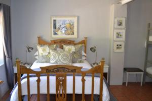 a bedroom with a wooden bed with pillows at Rooiheuwel Cottage in Wellington