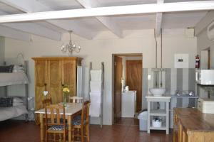 a kitchen and dining room with a table and chairs at Rooiheuwel Cottage in Wellington