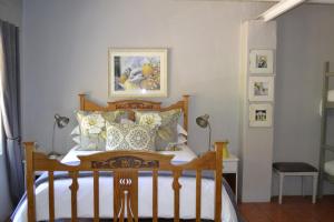 a bedroom with a bed and a picture on the wall at Rooiheuwel Cottage in Wellington