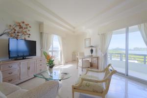 a living room with a tv and a large window at Palasia Hotel in Koror