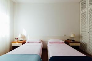 dwa łóżka w pokoju z dwoma stołami i dwoma lampami w obiekcie Residence Renaione w mieście Punta Ala
