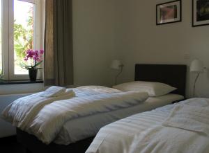 2 Betten in einem Schlafzimmer mit Fenster in der Unterkunft Le Baron Apartments in Stavelot