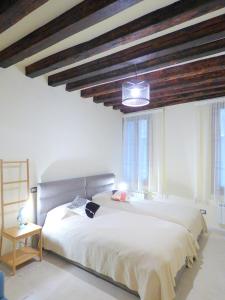 a bedroom with a large white bed and windows at Ca' Neldo - VeniseJeTAime in Venice