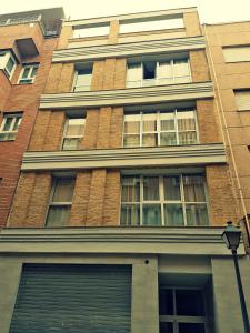 un edificio alto de ladrillo con ventanas y luz de la calle en Flatsforyou Marina Playa, en Valencia