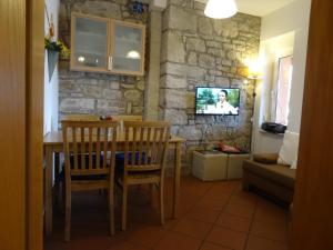 a dining room with a table and chairs and a tv at Gutshof Großheringen - Ferienwohnung 4 Personen in Großheringen