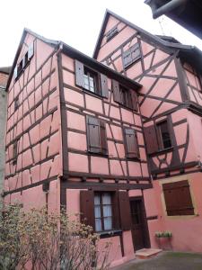 un edificio rosa con ventanas y puertas en Baribal'ele en Colmar