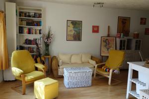 sala de estar con sillas amarillas y sofá en Casa Marlela, en Brucoli
