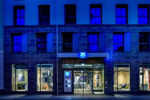 a store front of a brick building at night at Ibis Budget Leipzig City in Leipzig