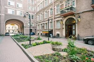 a city street with buildings and a courtyard with flowers at Anabel at Nevsky 88 in Saint Petersburg