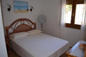 ein Schlafzimmer mit einem Bett mit weißen Laken und einem Fenster in der Unterkunft Villa Magnolias in Benitatxell + 38 Fotos