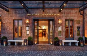 um edifício com dois bancos à sua frente em Hotel Die Sonne Frankenberg em Frankenberg