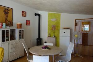 cocina con mesa, sillas y nevera en Casa Marlela, en Brucoli