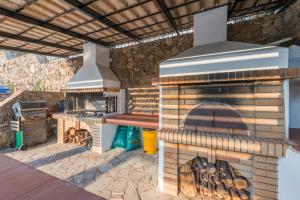 an outdoor kitchen with a large brick oven at Villa Adamite in Sounio