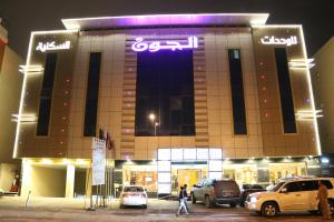ein Gebäude mit nachts vor ihm geparkt in der Unterkunft Al Joon Aparthotel in Riad