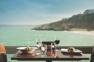 un tavolo con due piatti di cibo e bicchieri di vino di Pedn-Olva a St Ives