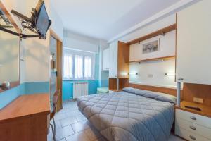 フィナーレ・リーグレにあるHotel Santa Mariaのベッドとテレビが備わるホテルルームです。
