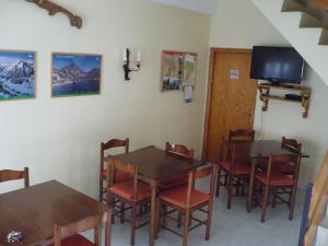 a dining room with tables and chairs and a tv at Casa Nando in Esterri d'Àneu