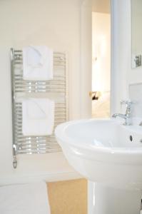 Baño blanco con lavabo y espejo en Balmoral Guest House en Darlington