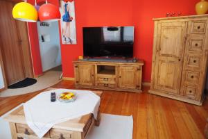 een woonkamer met een flatscreen-tv en een tafel bij "Zur Schmücke 69" in Ilmenau