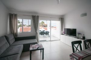 a living room with a couch and a television and a table at Apartment Eden Island Village in Adeje
