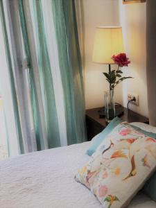 a bedroom with a bed and a vase with a rose at Casa Antón in Seville