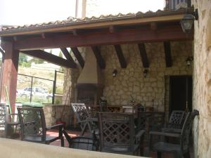 un patio con sillas y una pared de piedra. en La Tejada del Valle, en Valle de San Pedro