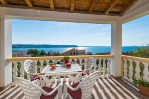 d'une table et de chaises sur un balcon avec vue sur l'océan. dans l'établissement Apartments Marko Dominik, à Ražanac