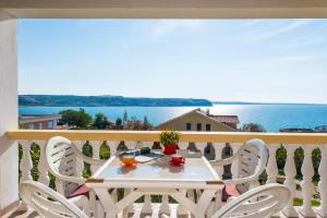 - une table sur un balcon avec vue sur l'océan dans l'établissement Apartments Marko Dominik, à Ražanac