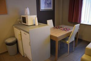 een kleine keuken met een tafel en een magnetron bij City Apartments Antwerpen in Antwerpen