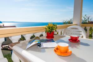 uma mesa com um livro e chávenas de café numa varanda em Apartments Marko Dominik em Ražanac