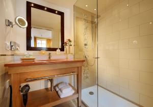 a bathroom with a tub, sink and mirror at Hotel Die Sonne Frankenberg in Frankenberg