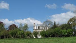 オーディエルヌにあるchambres d'hotes du Manoir de Suguensouの田地の丘の古家