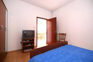 1 dormitorio con 1 cama, TV y ventana en Villa Rosanda Apartments en Trogir