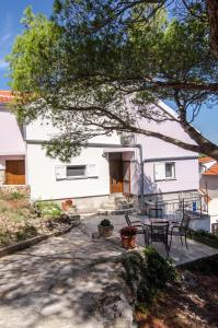 un patio con mesa y sillas frente a una casa en Apartment Teuta, en Isla Žirje