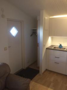 Habitación con cocina y puerta con fregadero en Lillstugan Falköpingsvägen, en Broddetorp