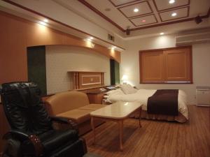 a hotel room with a bed and a couch and a chair at Hotel Hyper Noah (Adult Only) in Sakai