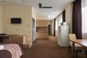 a room with a kitchen with a refrigerator and a table at Twin Apart Hotel in Kyiv
