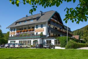 a large building with cars parked in front of it at Seehotel Schlick in Fuschl am See