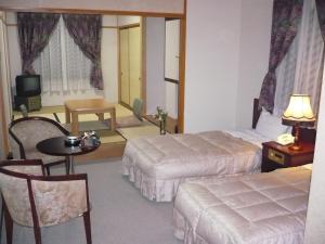 南礪的住宿－五箇山溫泉赤尾館旅館，酒店客房设有两张床和一张桌子。