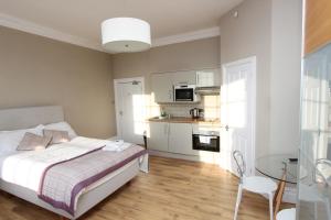 a bedroom with a bed and a table and a kitchen at Number 1 Park Apartments in Bristol