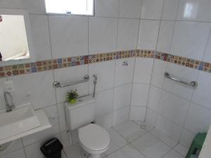 uma casa de banho branca com um WC e um lavatório em Pousada Sitio Costa Verde em Ubajara