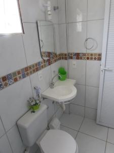 a bathroom with a sink and a toilet and a mirror at Pousada Sitio Costa Verde in Ubajara