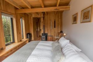 a bedroom with a large white bed with wooden walls at Lodge BordeBaker in Puerto Bertrand