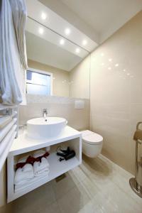 a white bathroom with a sink and a toilet at Lipotica Luxury Accommodation in Zadar