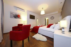 sypialnia z białym łóżkiem i czerwonym krzesłem w obiekcie Lipotica Luxury Accommodation w mieście Zadar