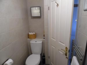 a small bathroom with a toilet and a door at Langdon Farm Cottage in Boyton +16 photos