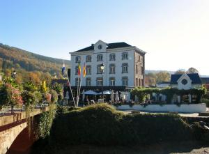 a large building with a bridge in front of it at Le Baron Suites & Apartments in Stavelot