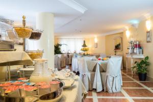 un comedor con mesas con manteles blancos en Hotel Vecchio Borgo en Palermo